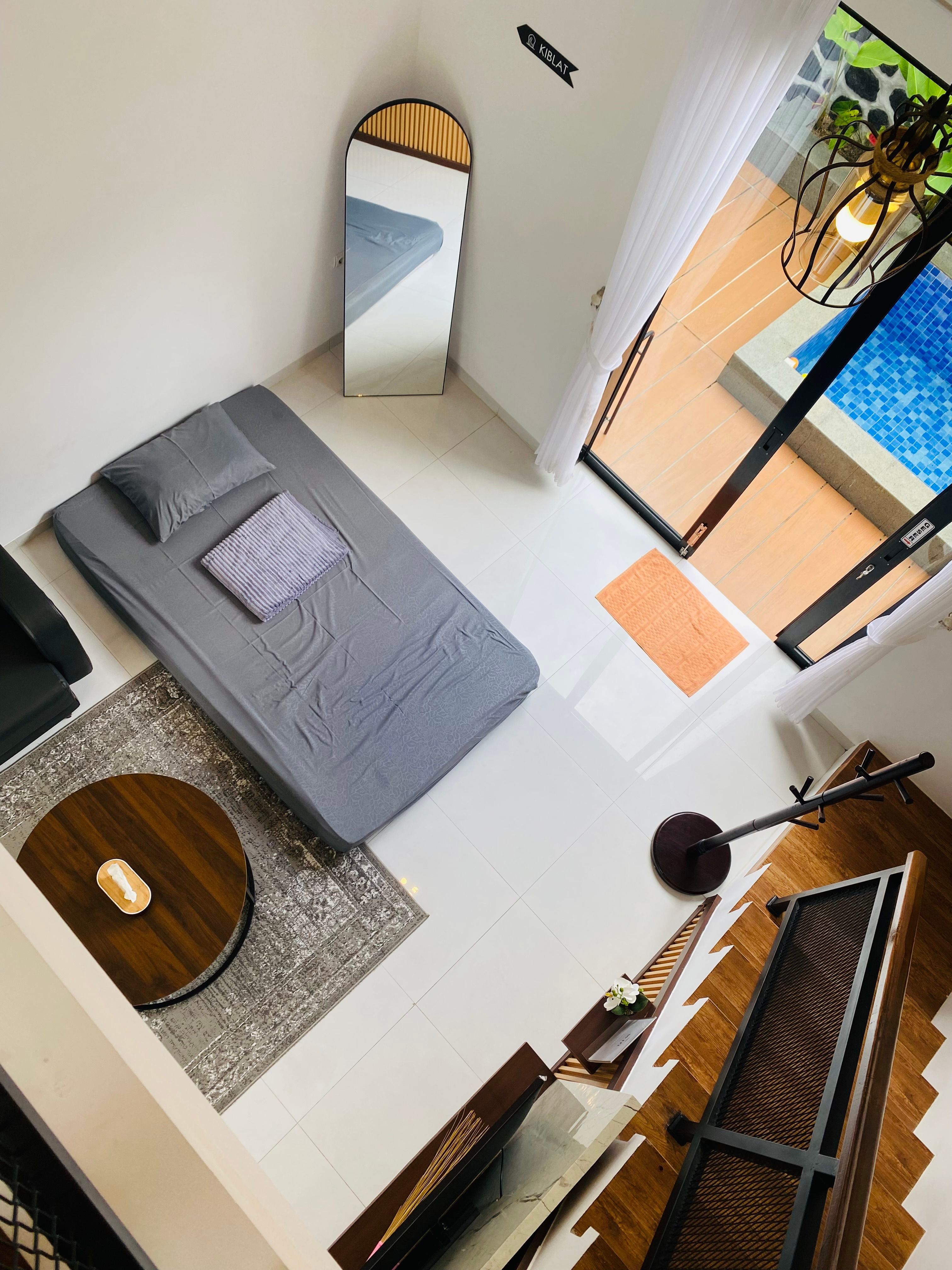 Small apartment living room with a high ceiling and natural light, showing open overhead space for a home gym setup
