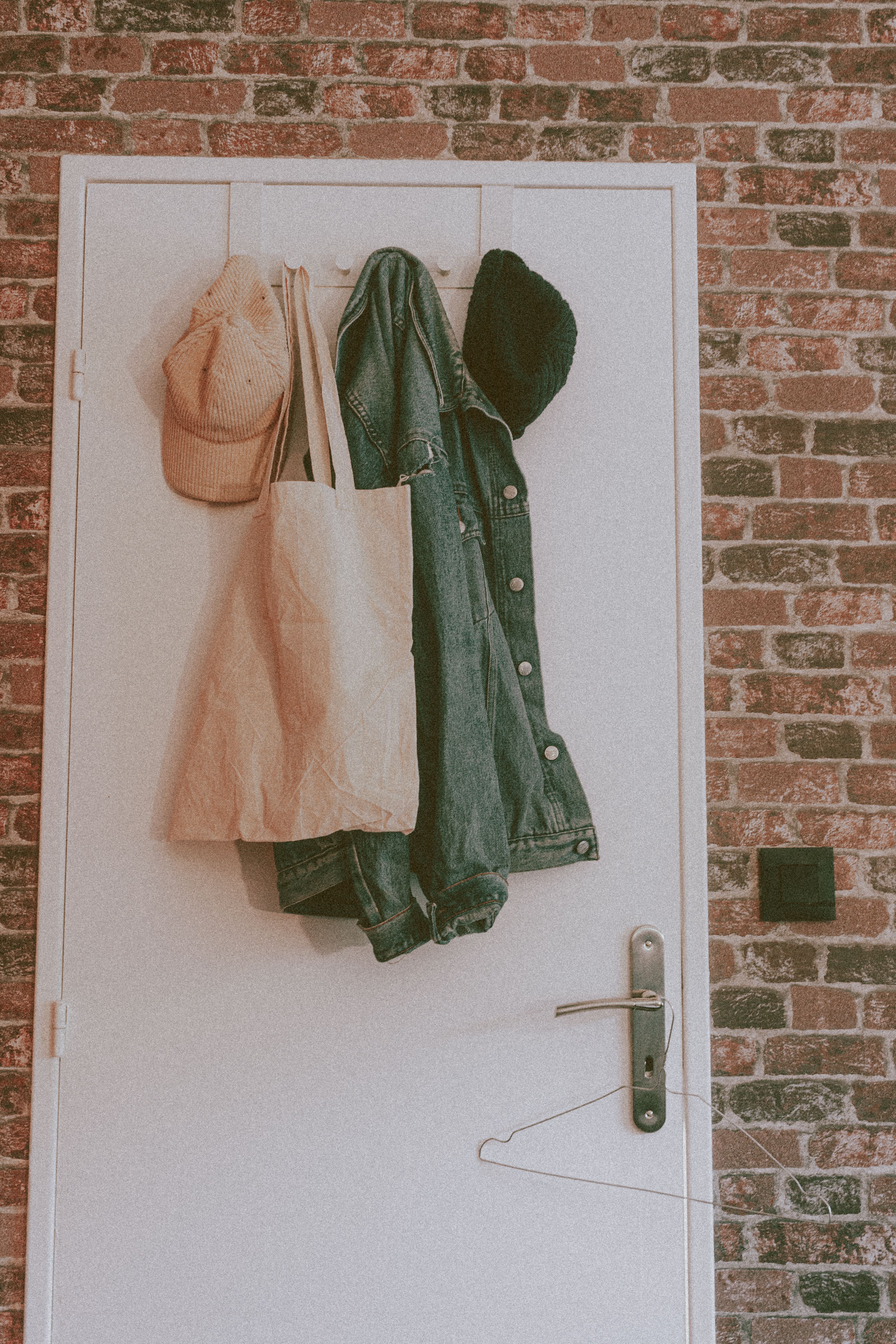 An over-the-door hook organizer holding workout gear in a small room.