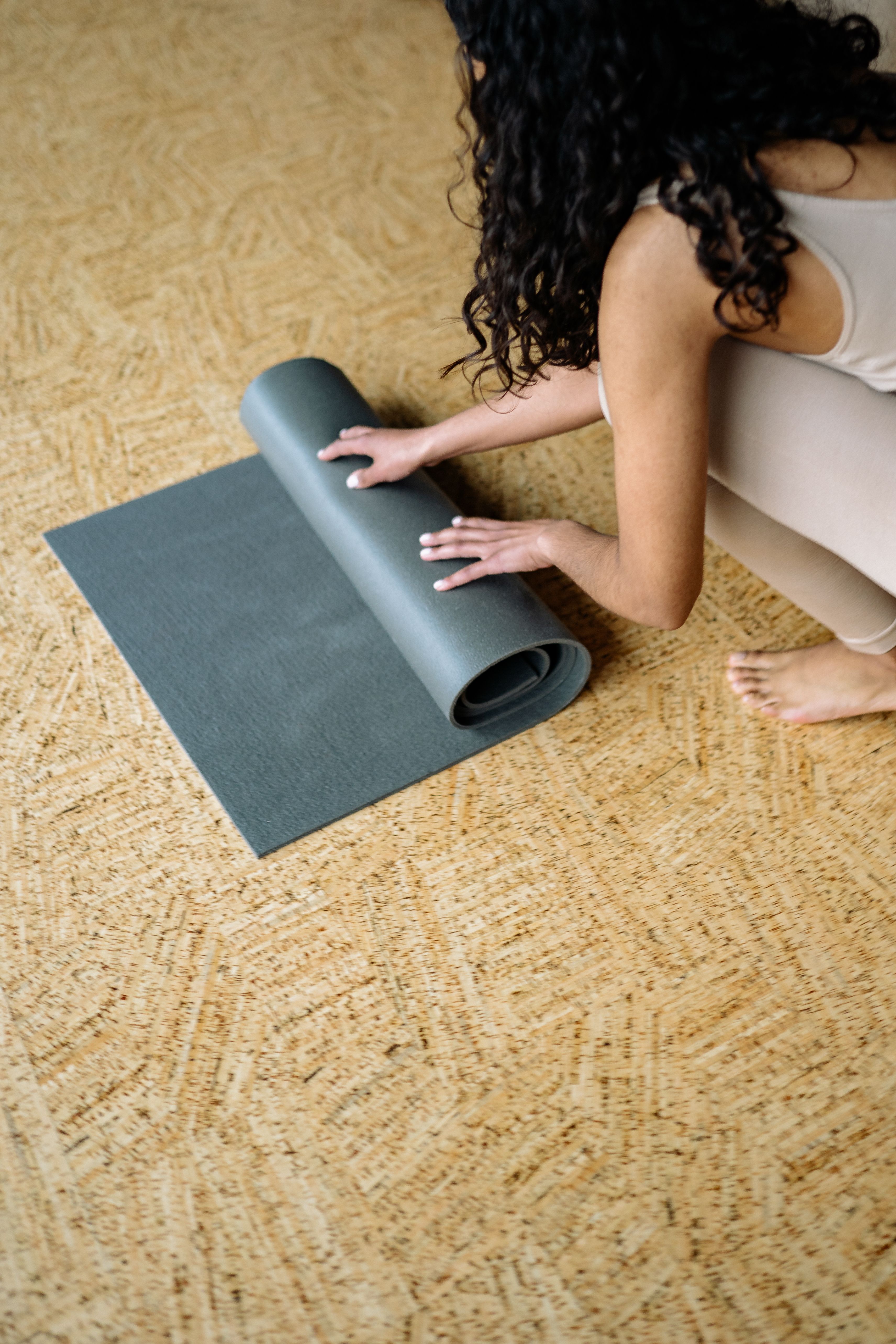 A black equipment mat protecting a hardwood floor under home gym gear.