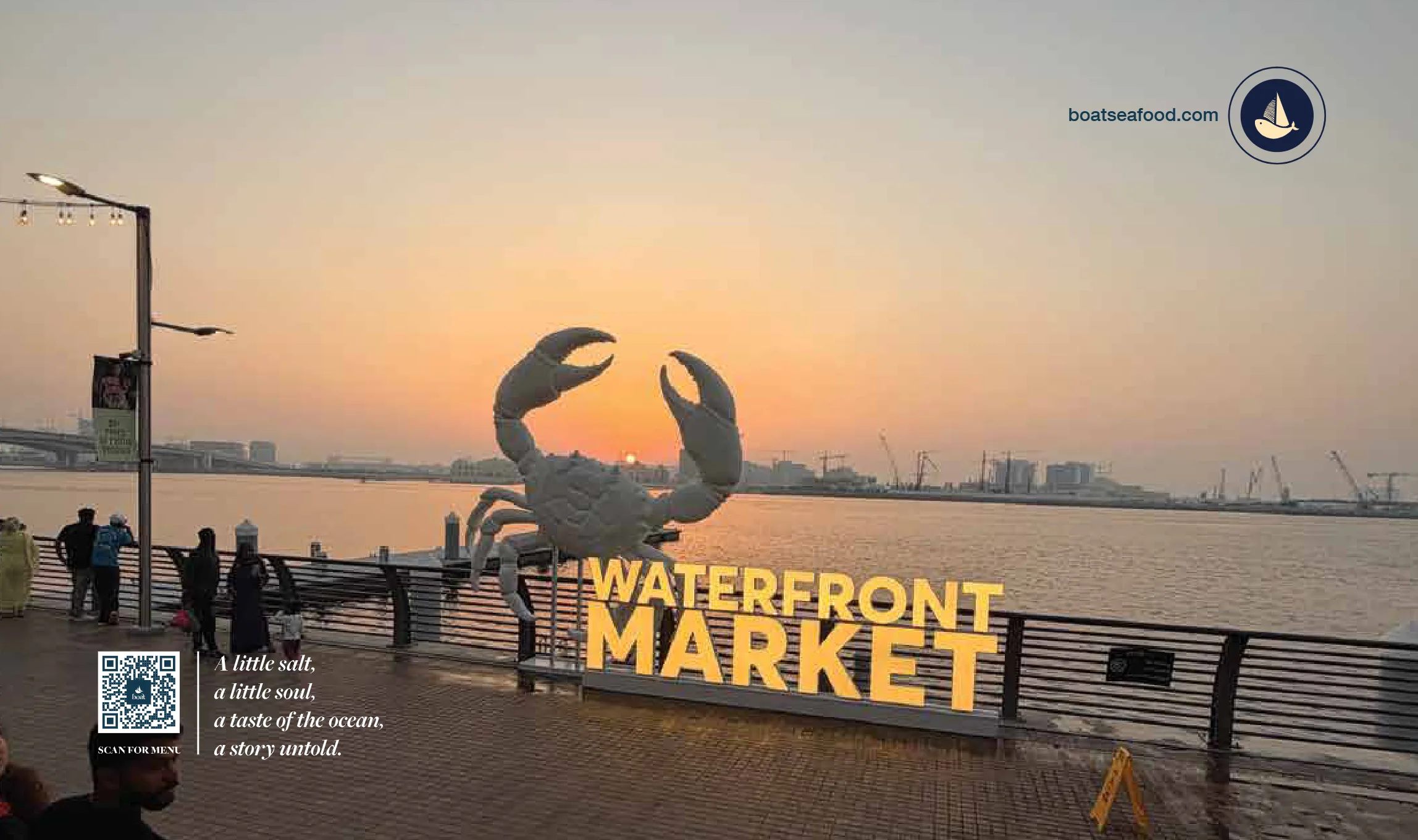 The crab sculpture and Waterfront Market sign at sunset