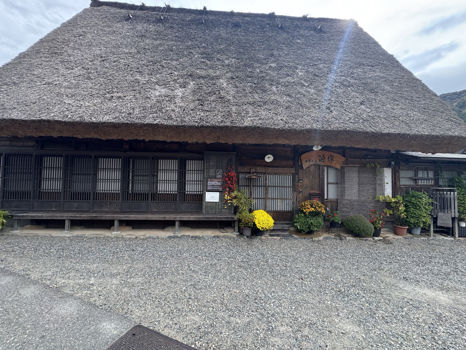 The Gensaku guesthouse beneath its broad thatched roof.
