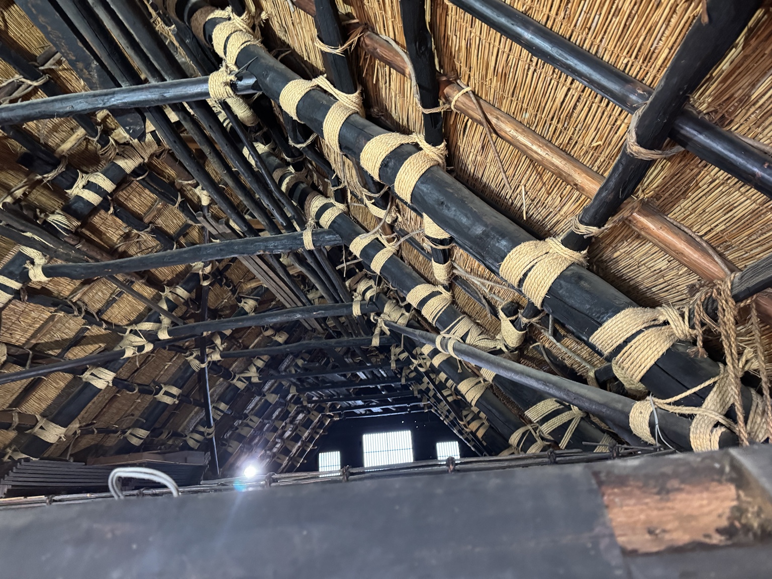 Beneath the roof: sturdy timber beams and rope lashings.