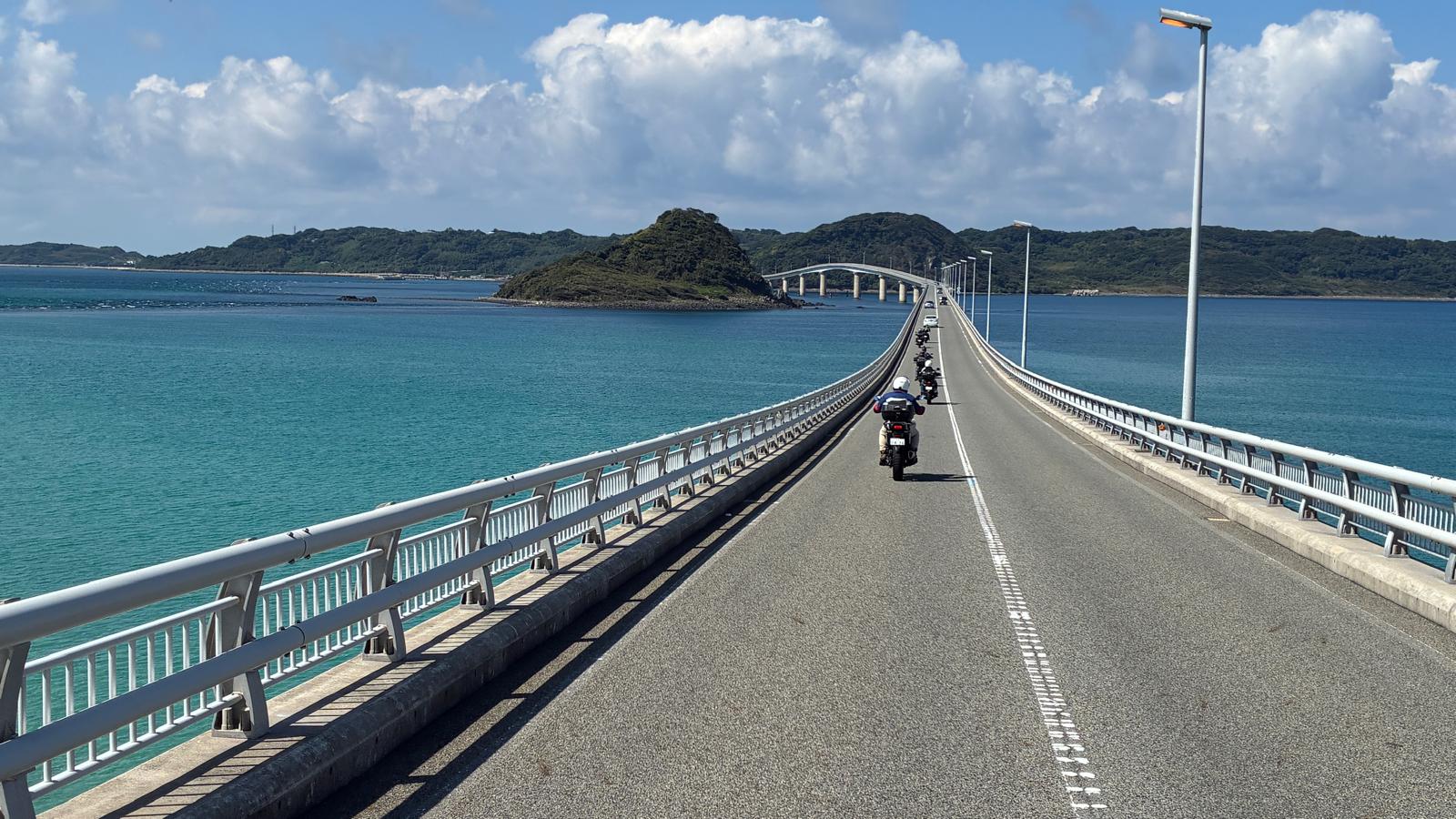 A motorcycle on a bridge above turquoise water