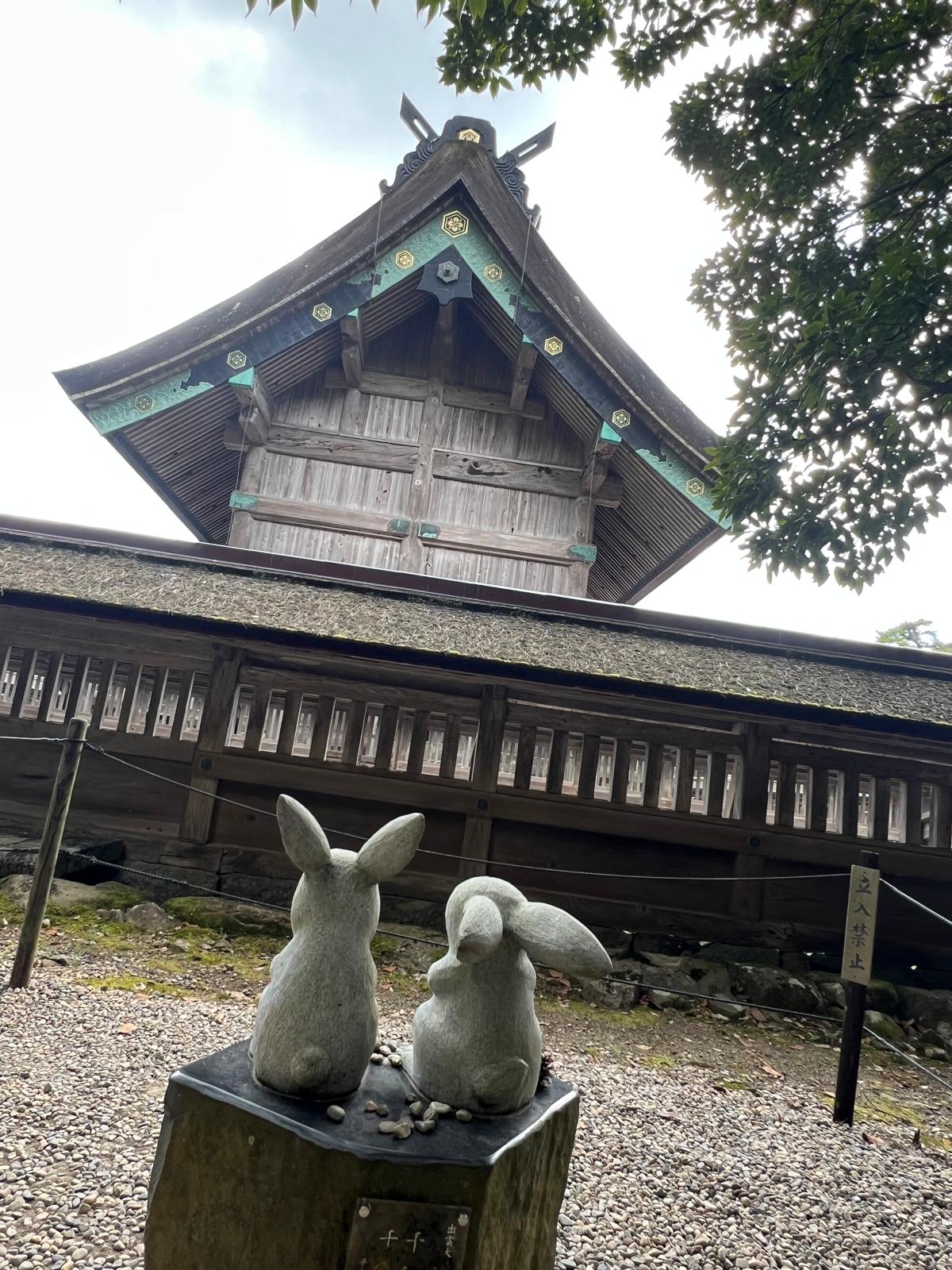 Two rabbit figures outside a traditional building