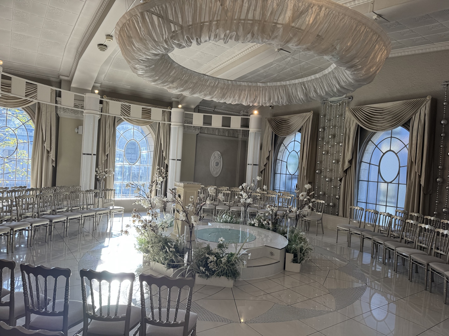 Stuhlreihen und Blumenschmuck im Hochzeitsraum des Hotels.