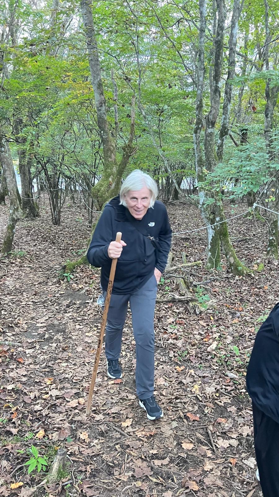 Kurt with a walking stick in the woods.