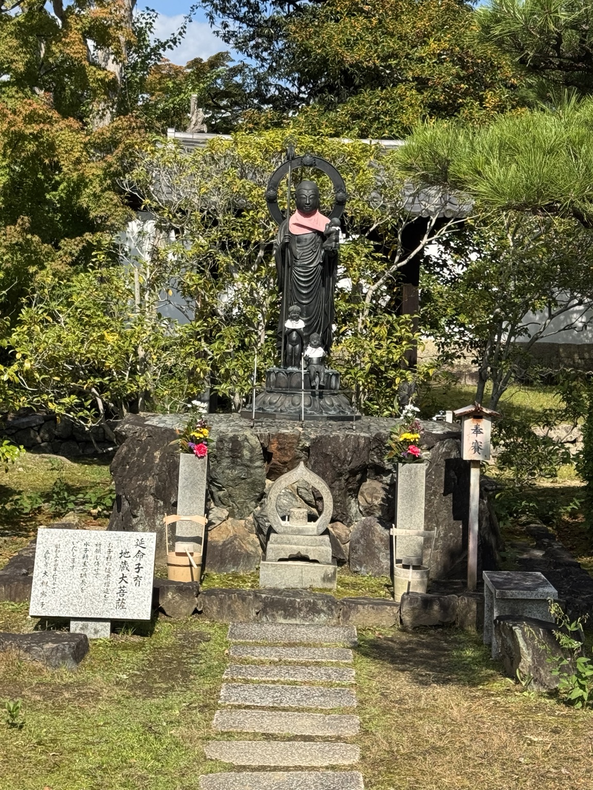 A statue among trees and stone monuments.