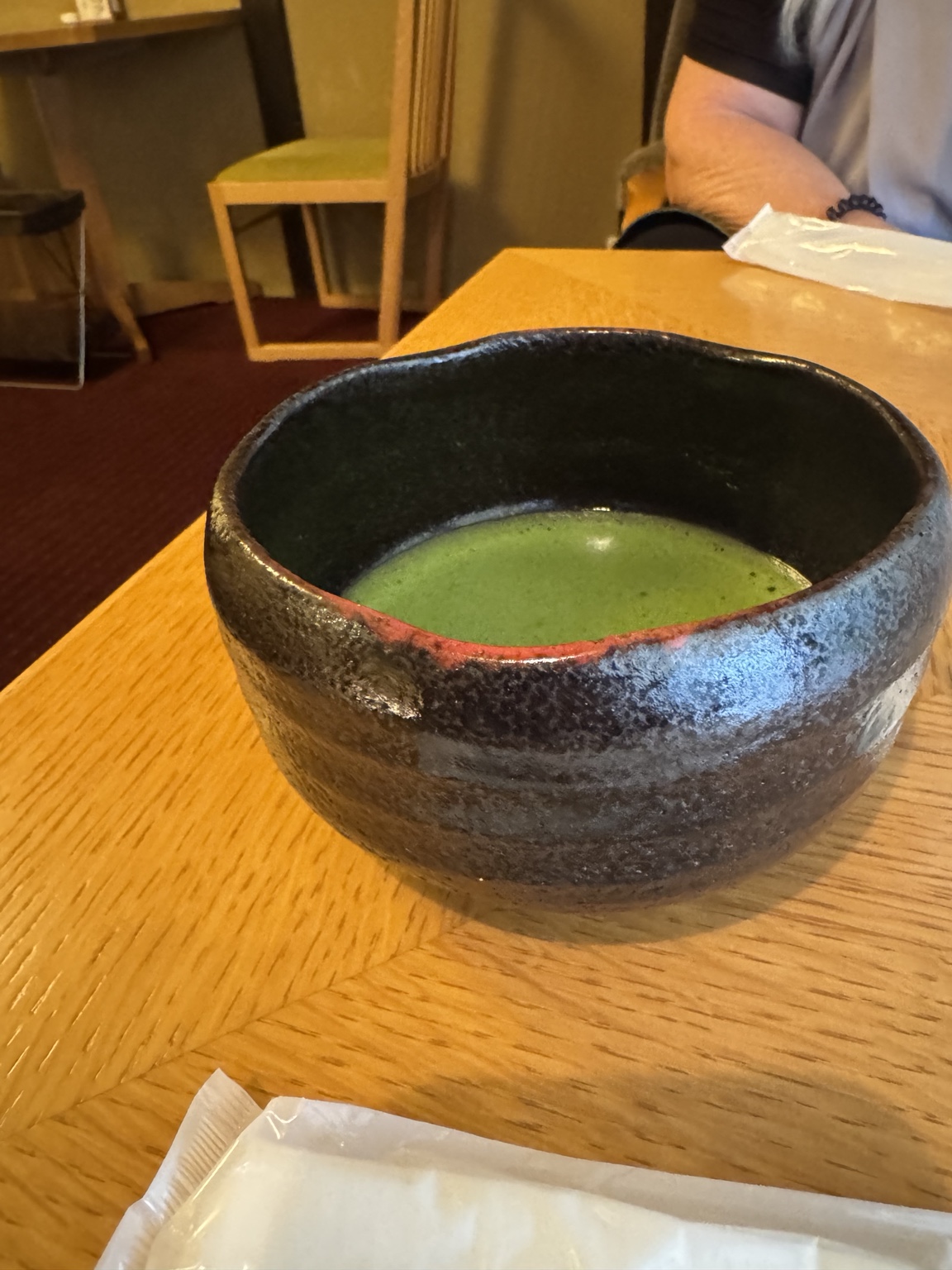 Green matcha in a dark ceramic bowl