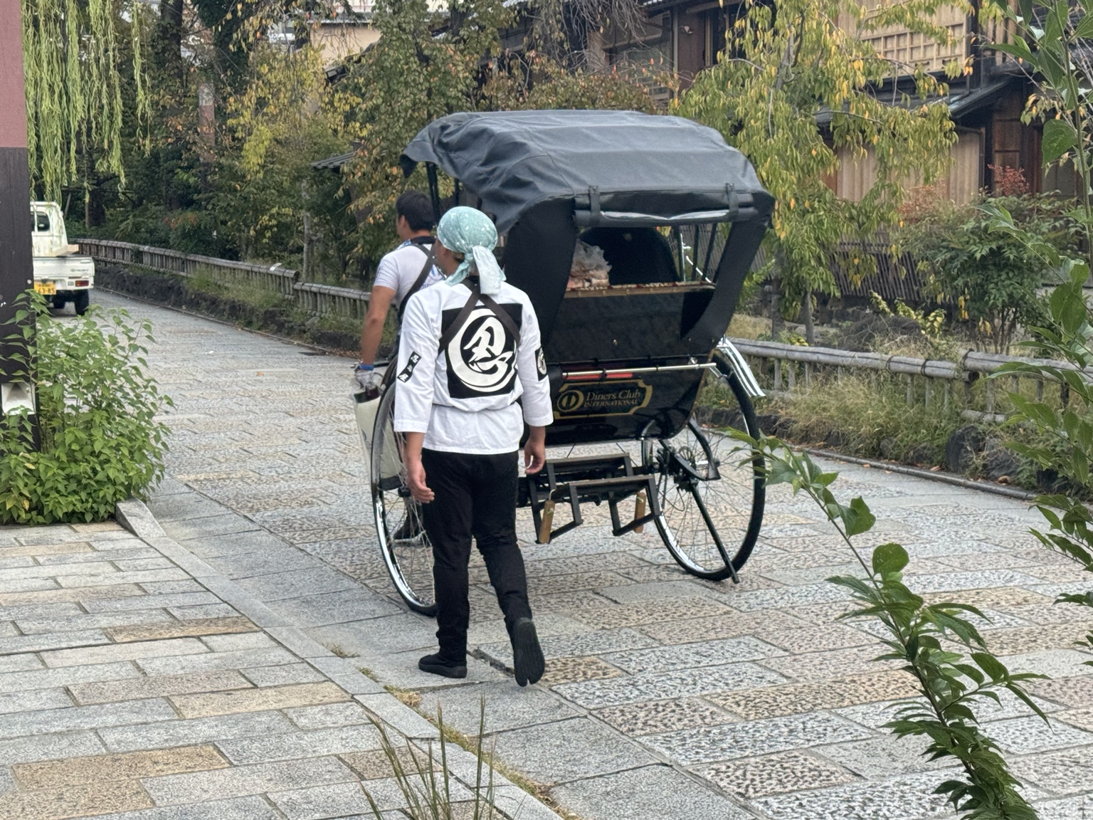 A rickshaw and attendant on the riverside path