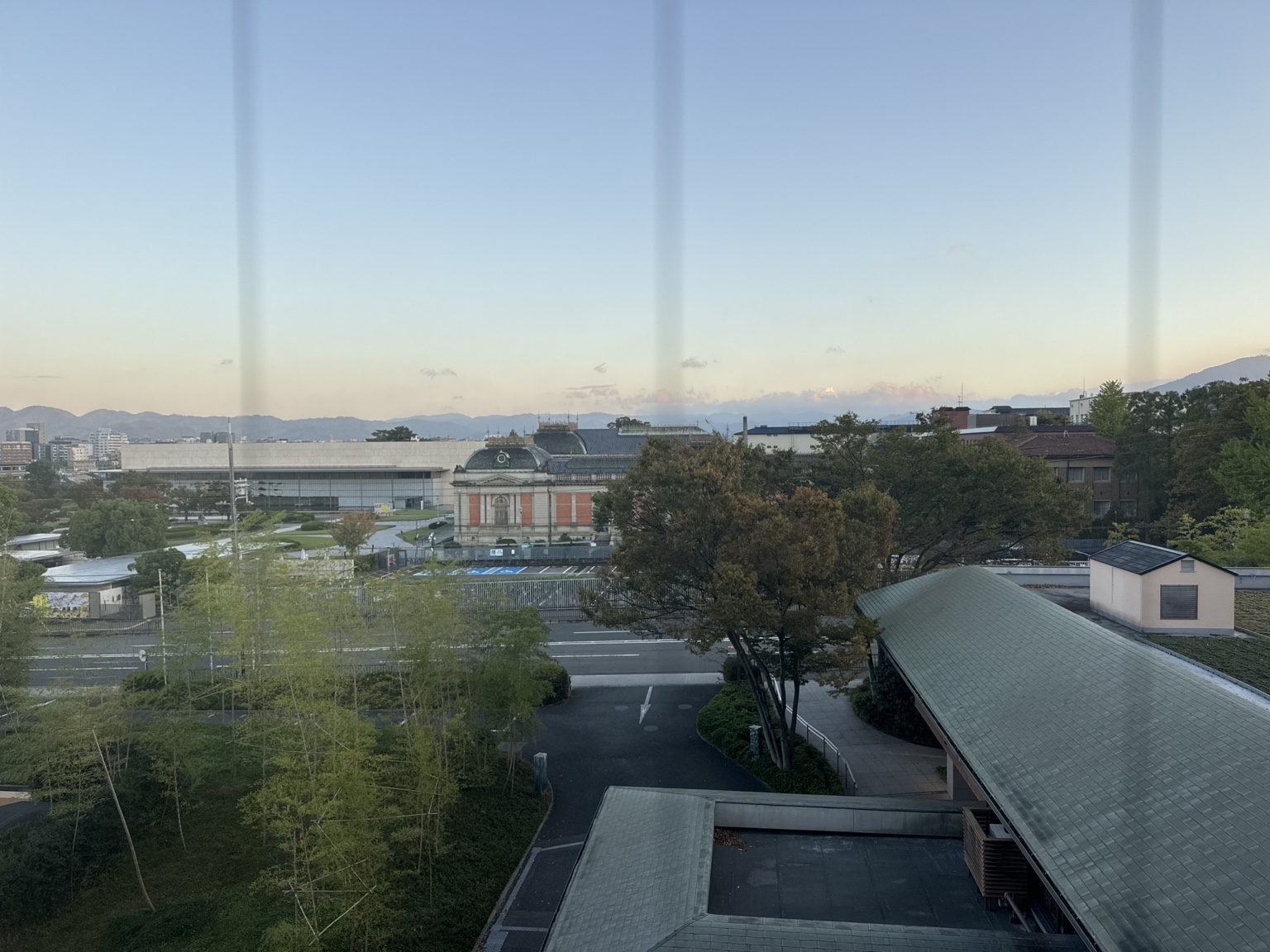 The view from our hotel room across to Kyoto National Museum, trees and the mountains beneath an almost cloudless sky.