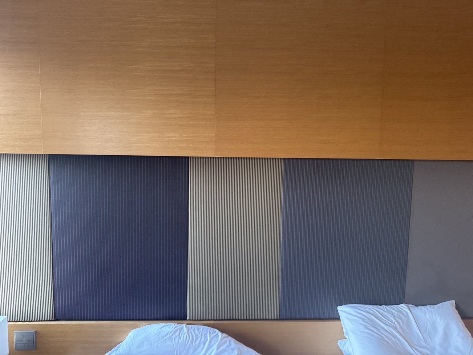 Wood and striped fabric at the head of the bed.