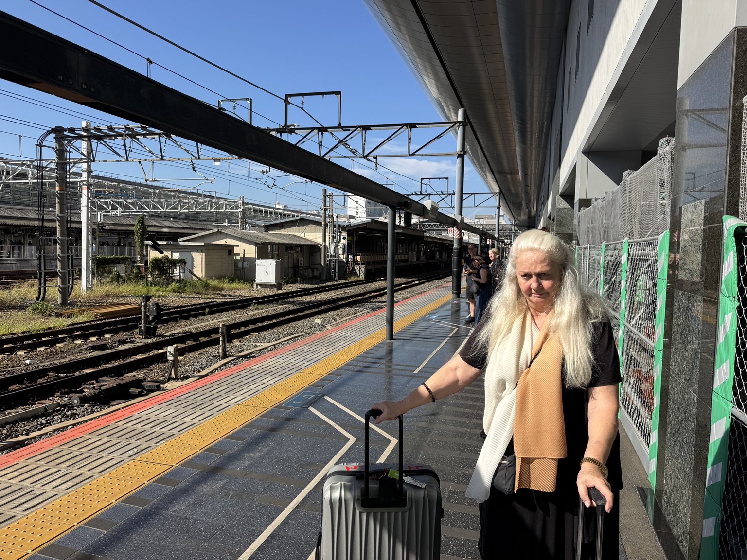 Anneliese with a suitcase on the platform.