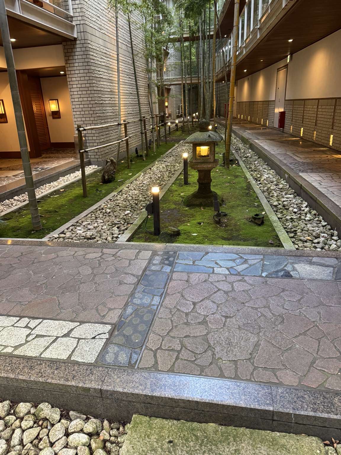 Bamboo and a stone lantern between the buildings.