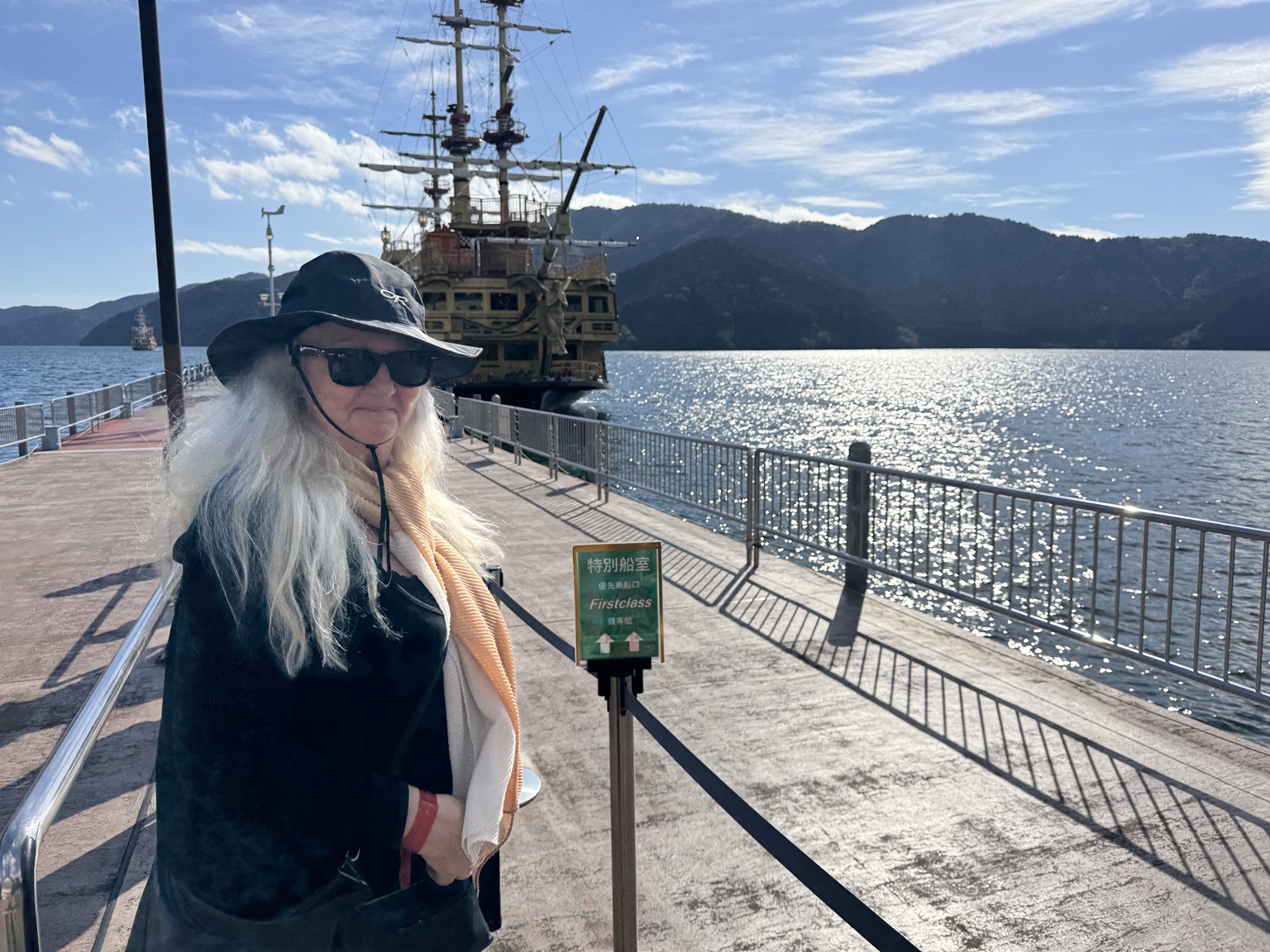 Anneliese at the pier with a pirate ship on Lake Ashi