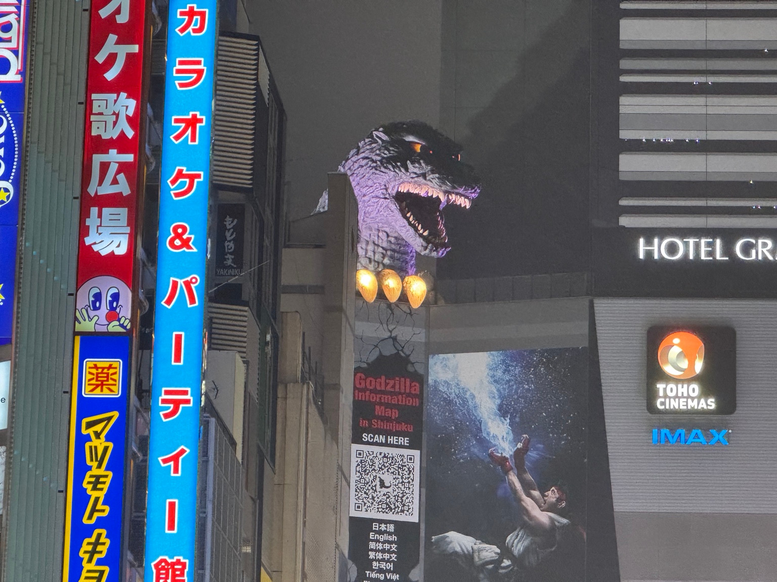 Godzilla schaut zwischen den Fassaden hervor.