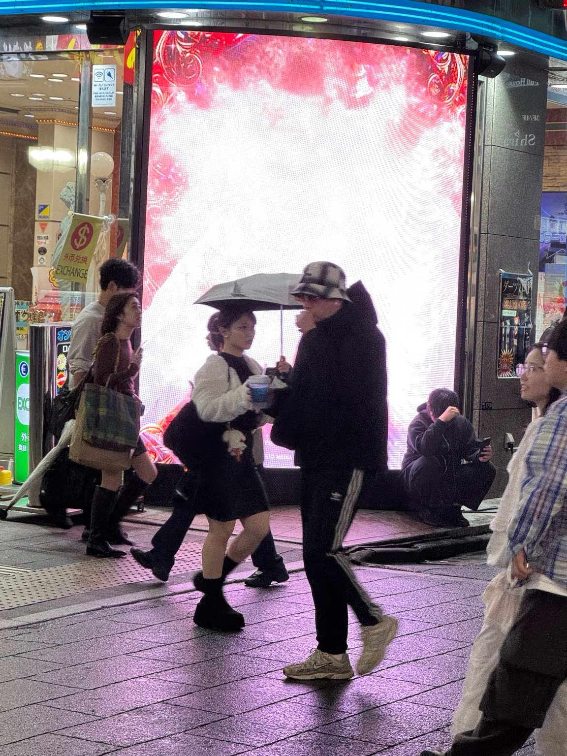 Schirme und leuchtende Reklame im nächtlichen Tokio.