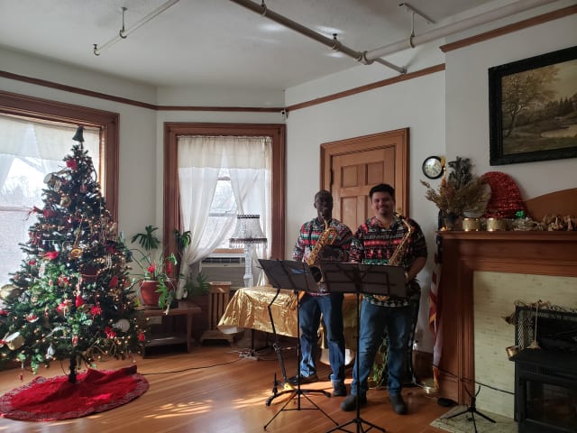 Musicians performing beside the Christmas tree in the parlor
