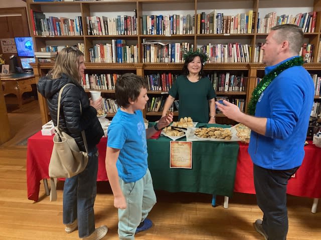 Guests gathered around a refreshments table in the school library