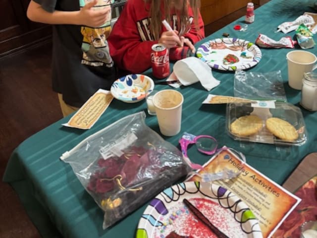 Two children painting at the holiday craft table