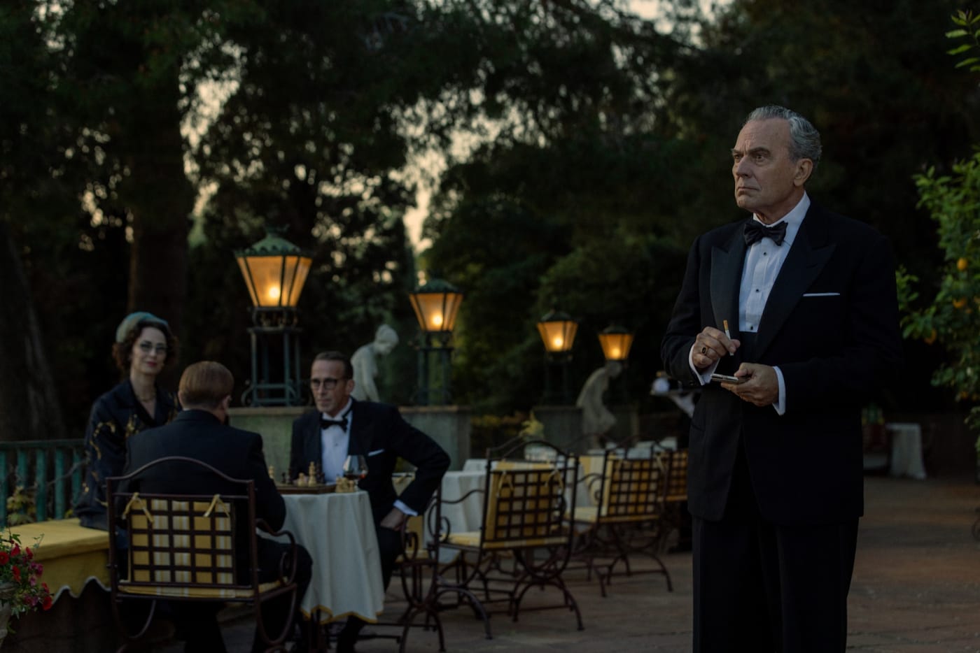 Terraço do hotel iluminado por lanternas, à noite, na série El problema final