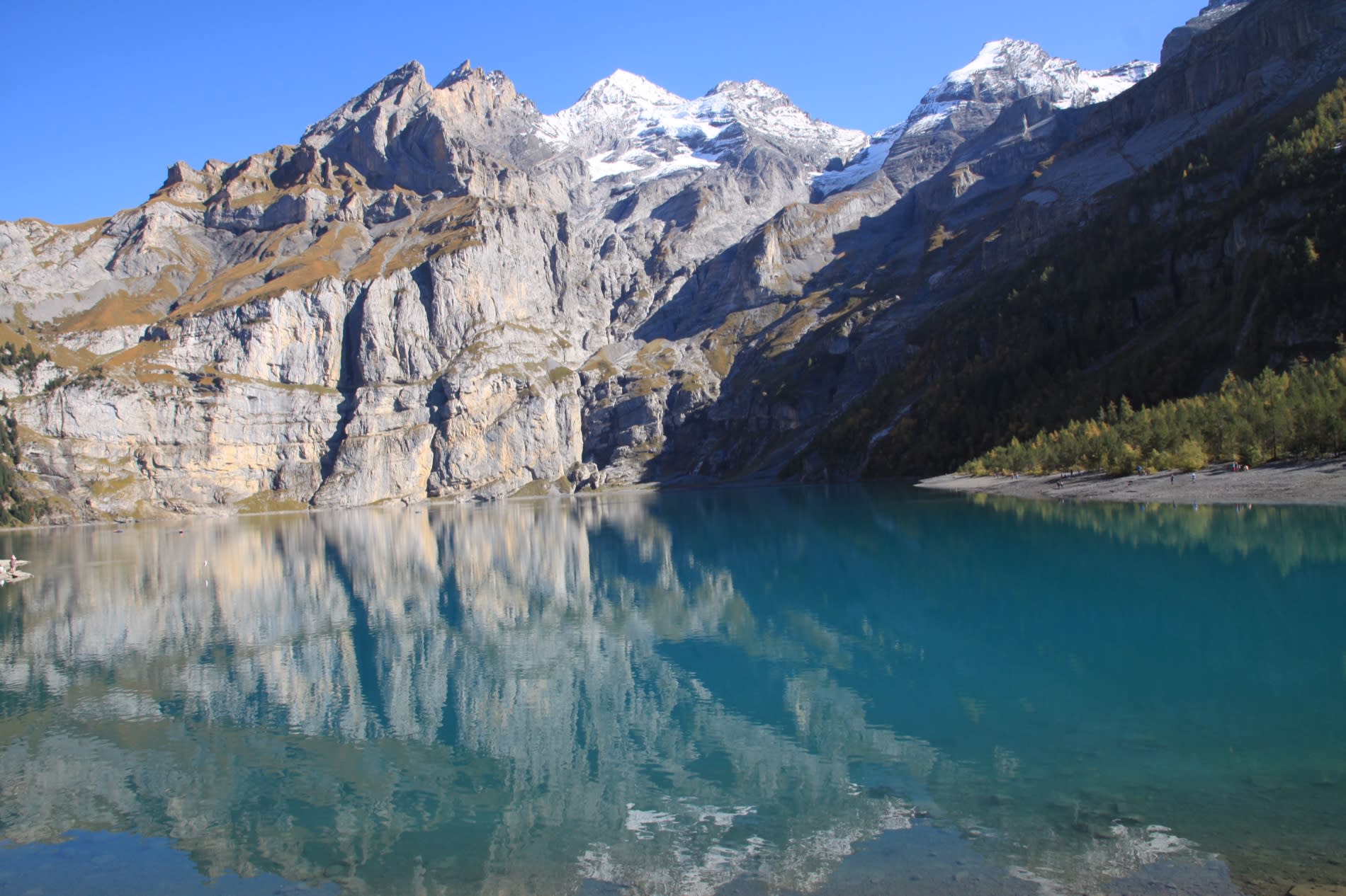 The turquoise lake of Oeschinensee and the snow-capped Alps in Switzerland, a luxury coolcation destination