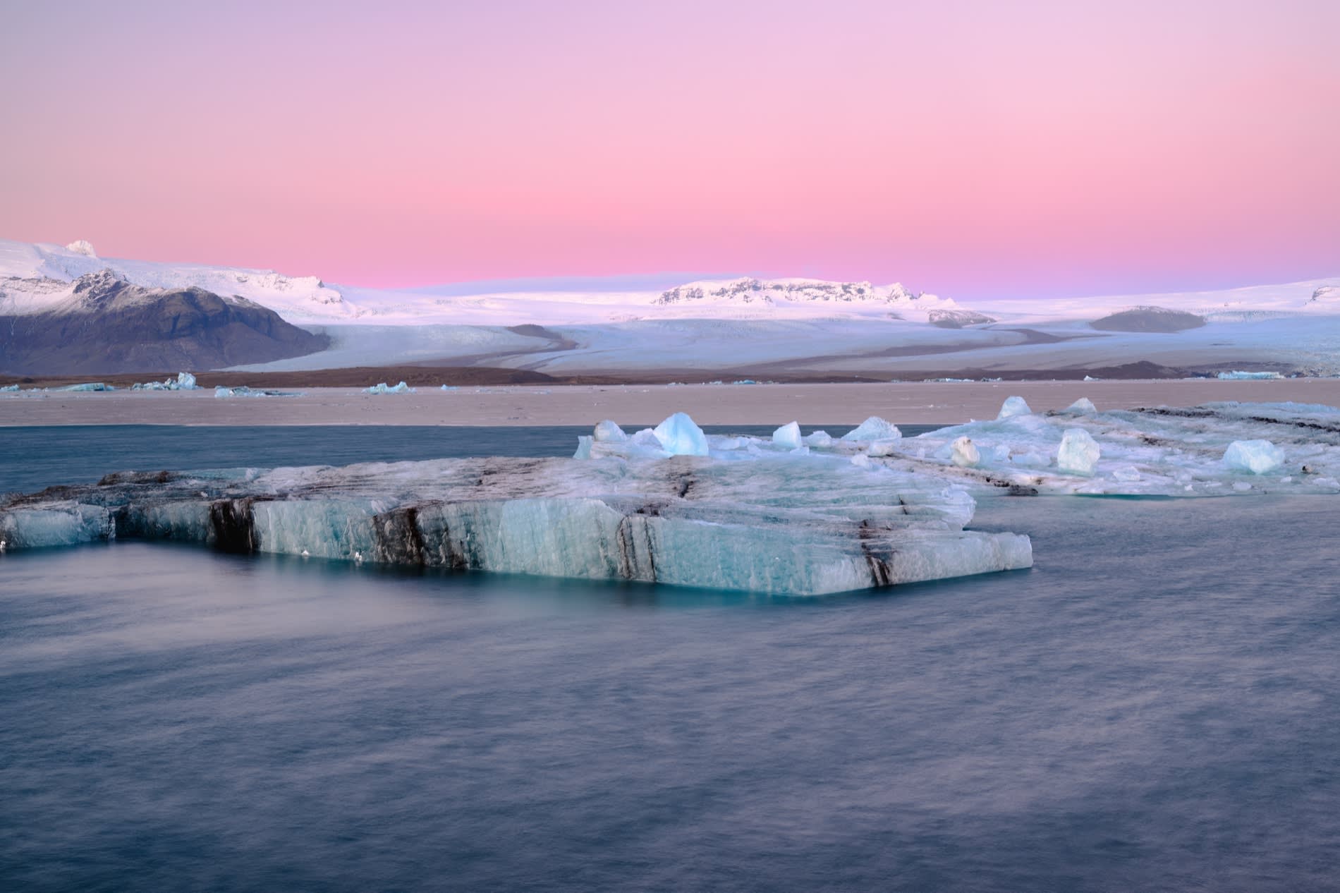 The glacial lagoon of Jökulsárlón in Iceland, icebergs under a pink sky