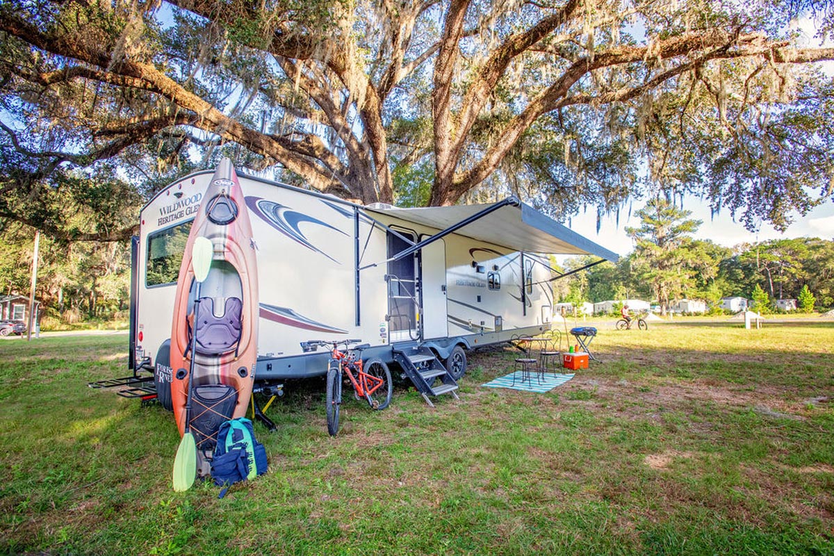 RV with kayak and bicycles under oak tree