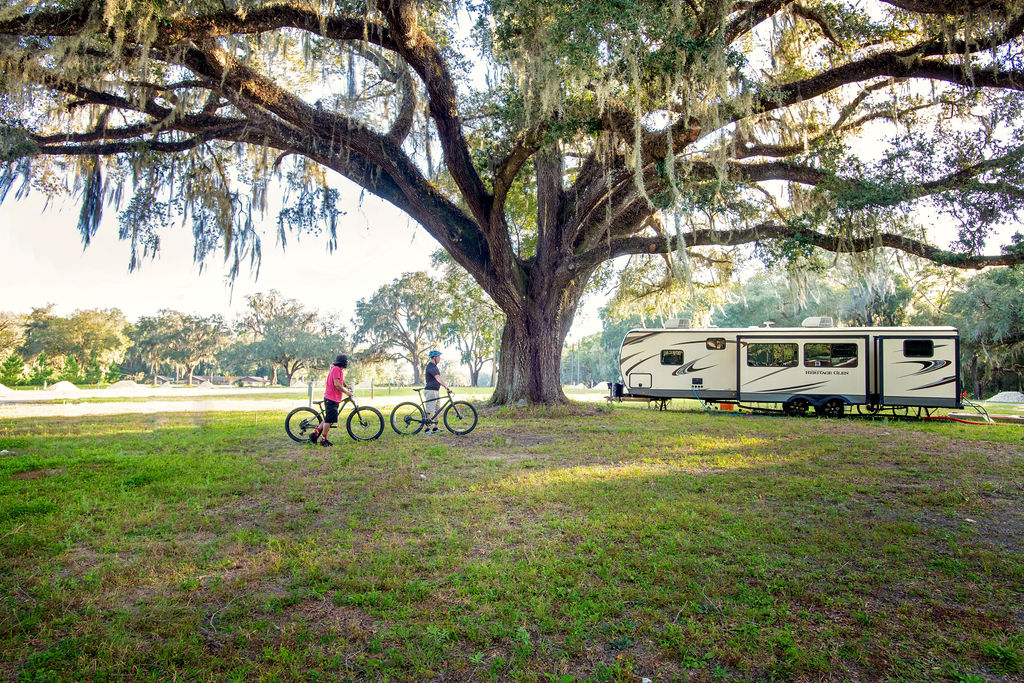 Cyclists walking bikes near RV site