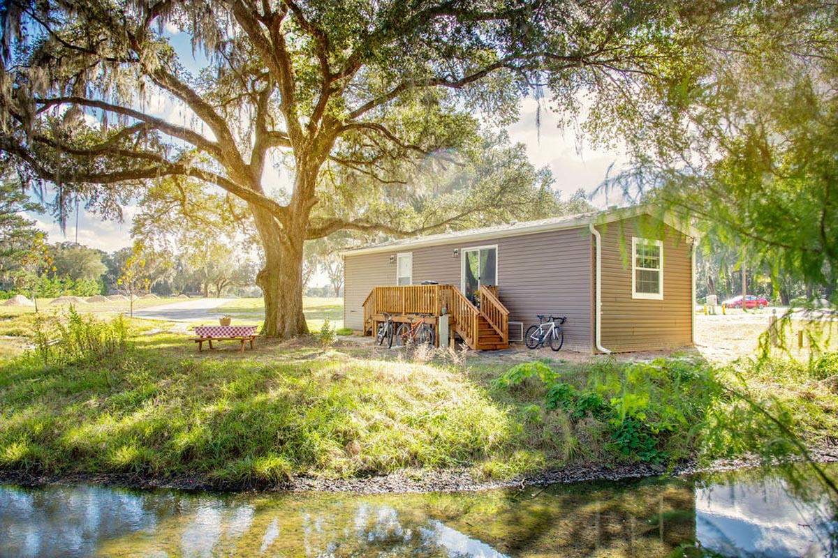Cabin exterior with bikes parked, trees and grass