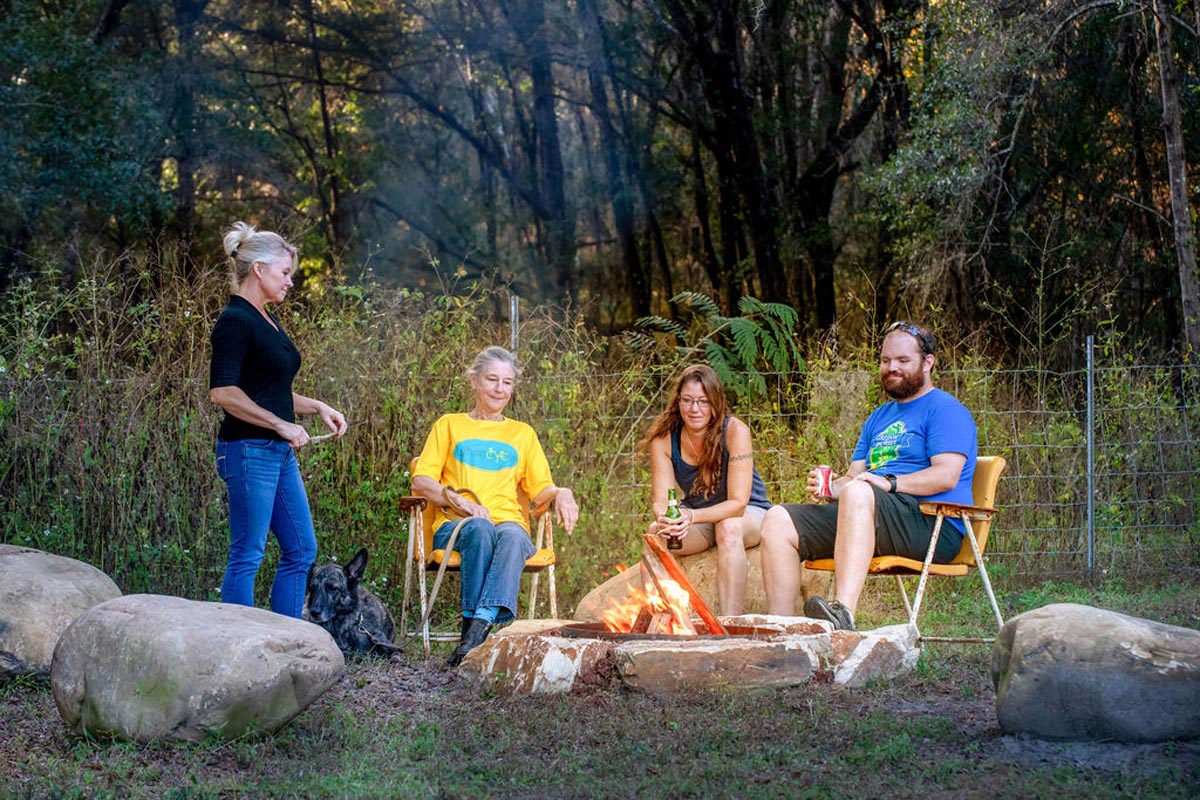 People smiling around campfire