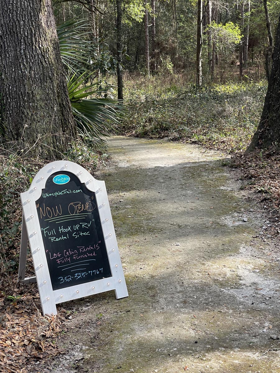 Group of cyclists at Santos Trails sign