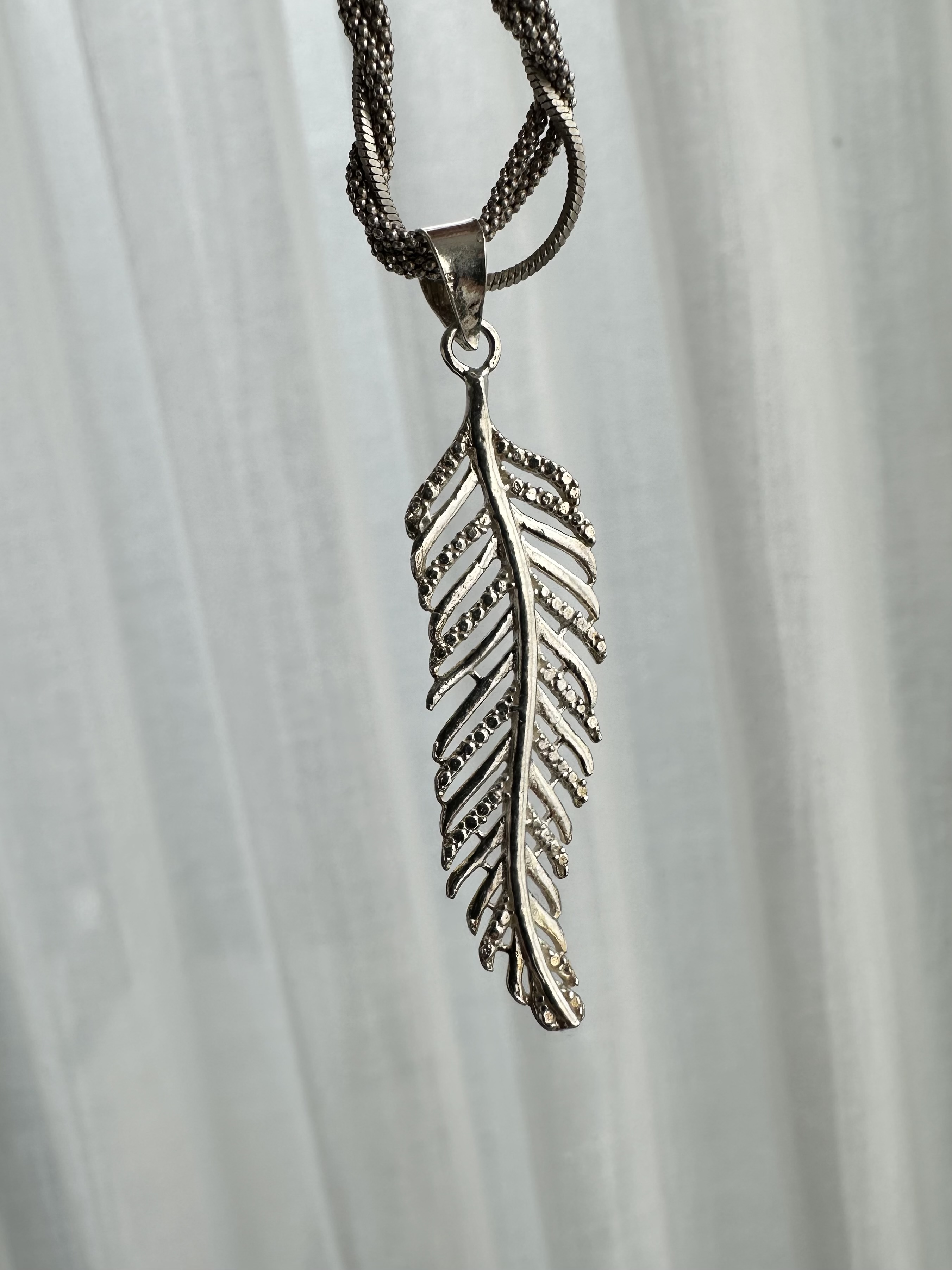 Dije de plata pluma 