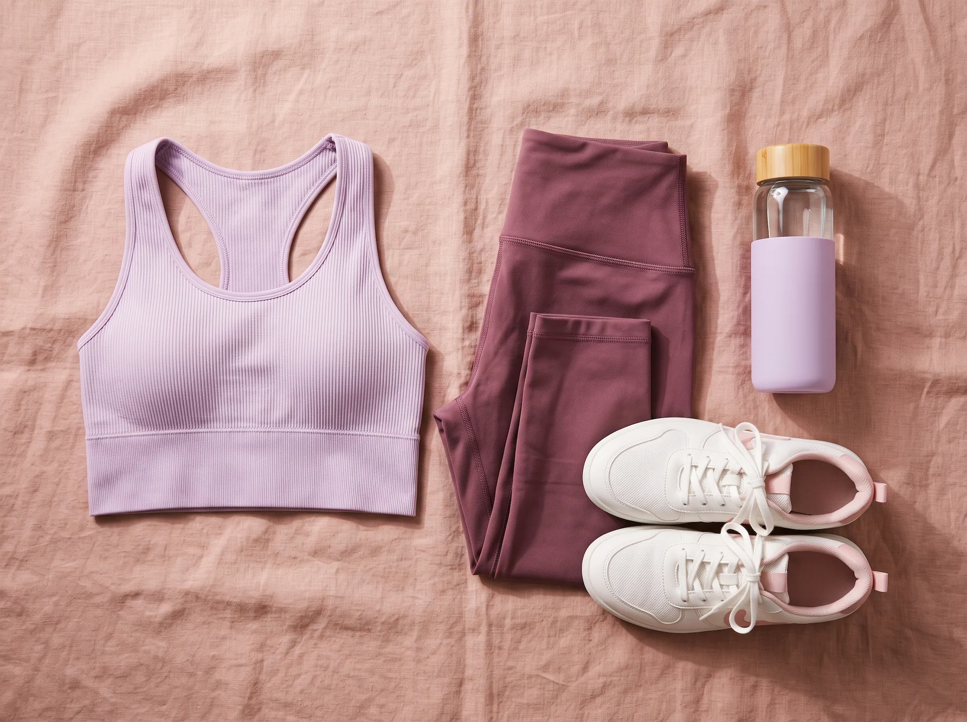 Sustainable activewear flat lay with sports bra, leggings, trainers, and bottle