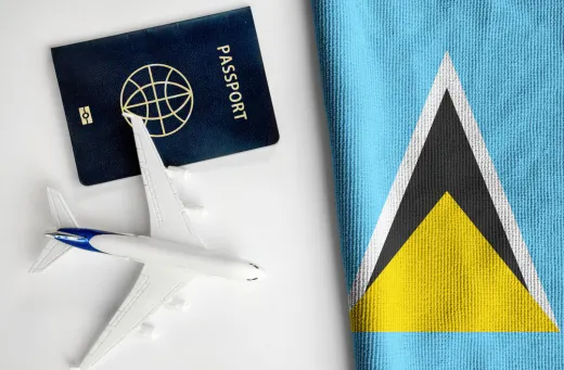Flag of St Lucia next to a passport and a scale-model airplane
