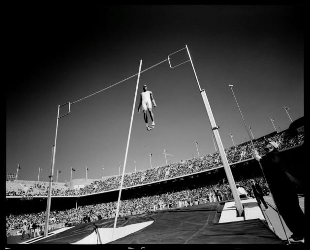 US Champion pole vaulter, Lawrence Johnson flies over the bar at the Penn Relays in 1996. © David Burnett.