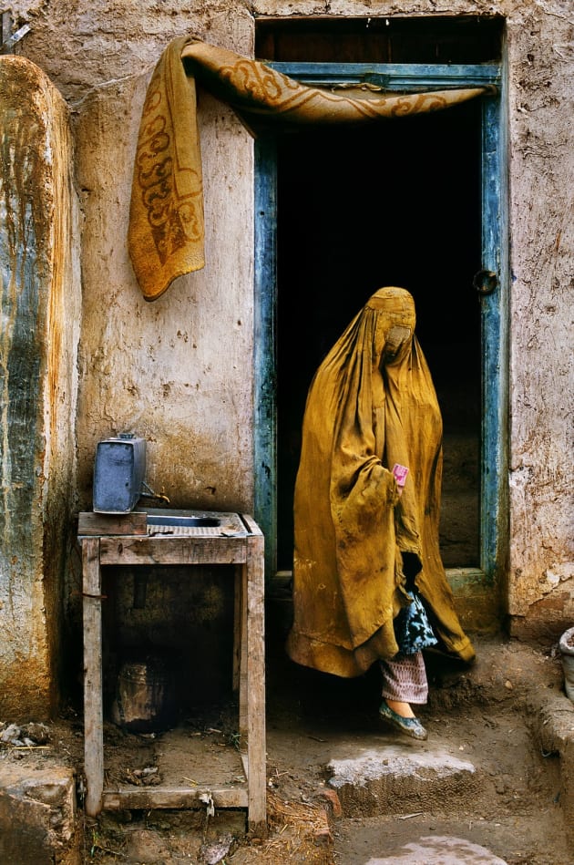 Faryab province, 1992. A widow reduced to begging comes out of a restaurant having just received money from a patron. With many men killed in the war, this once rare sight has become all too common.