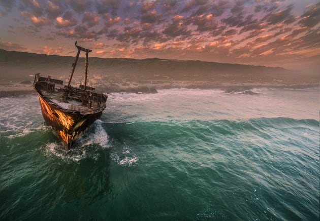 Ship Wreck at L’Agulhas by Dirke Heydenrych. A dramatic sunset is the perfect backdrop for this shipwreck off the Cape L’Algulhas headland in South Africa.
