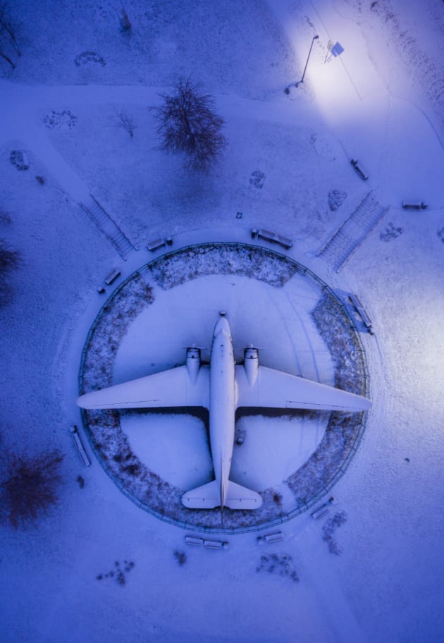 WWII airplane by Salim Madjd. A World War 2 airplane at the outdoor display of the Belarusian Great Patriotic War Museum is caked in snow from a light snowstorm overnight, with a photo taken during ‘blue hour’ in the early morning.