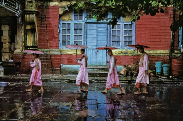 Procession of Nuns, Rangoon, Burma, 1994. Pictures can offer themselves up to you – but only if you have patience. McCurry asked these nuns if he could follow them on their daily walk around the city. He trailed them for several days until, with rain falling and a brightly coloured building as a fitting backdrop, he captured this graceful image. Copyright Steve McCurry.