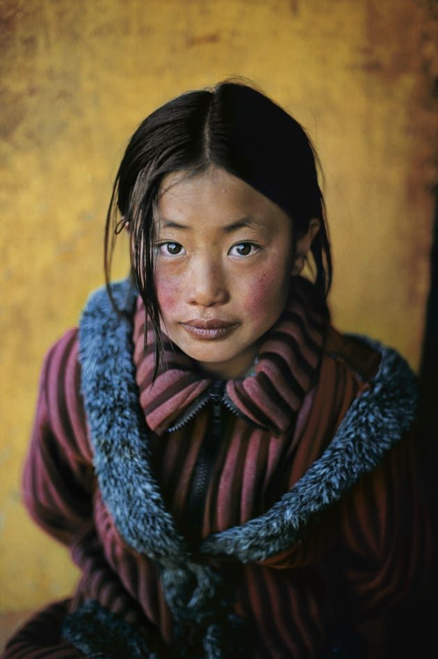 Girl in a Chinese coat. Xigazê, Tibet. 2001 © Steve McCurry / Magnum Photos. “I photographed this girl in her new Chinese-style coat in Xigazê, Tibet's second largest city. She wore it with pride. 
I like to get in close when I make portraits so that distracting elements don't interfere with the person's expression. It was easy to establish a rapport with this girl and her family. I think of taking portraits as making a family album of our time. This picture is one page of that album.” — Steve McCurry