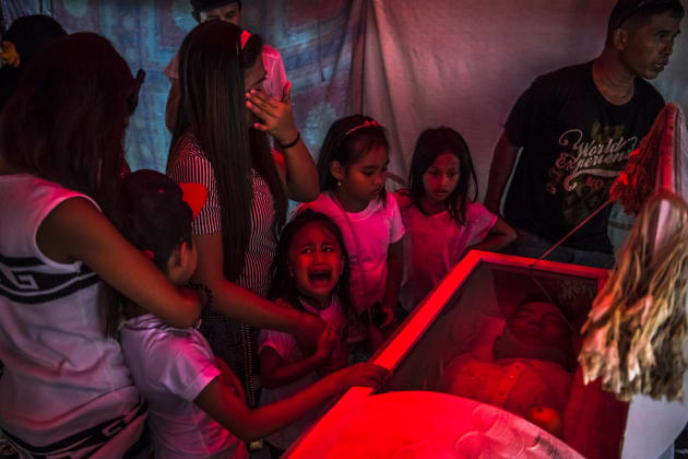 Jimji Bolasa (6) cries before funeral parlor workers remove the body of her father, Jimboy, who was found dead after being abducted by unidentified men.