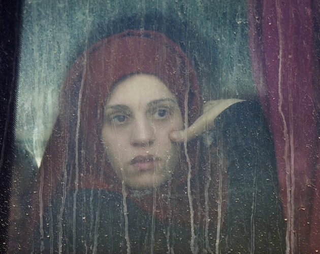 © Abbie Trayler-Smith, Fleeing Mosul, Iraq. After a nine-month battle, ISIS was expelled from Mosul in early 2017. I noticed Sara looking out of a window as the bus she was on pulled into the refugee camp. The look on her face summed up the global uncertainty that seemed to be everywhere. And yet, despite the death and destruction, the human spirit is resilient and lives on.