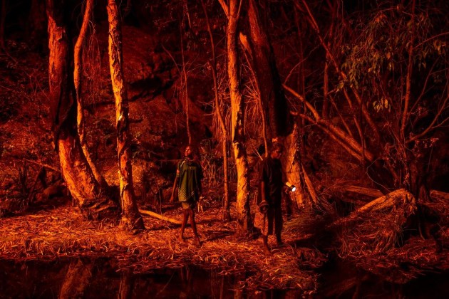 © Matthew Abbott. Stacey Lee (11, left) sets the bark of trees alight to produce a natural light source to help hunt for file snakes (Acrochordus arafurae), in Djulkar, Arnhem Land, Australia, on 22 July 2021.