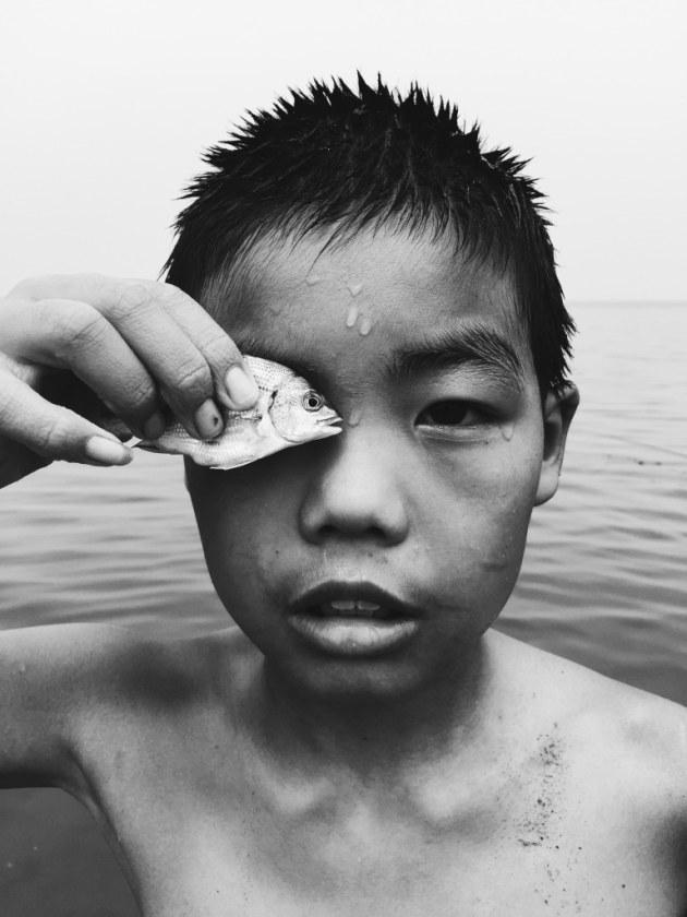 2nd Place, Photographer of the Year: Eye to eye by Huapeng Zhao, China
“I met this boy while walking at the seaside. When I was trying to take a picture of him, he put the fish he caught in front of his eye.“
Location: Yantai Shandong province, China. Shot on iPhone 6