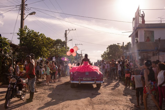 Pura rides around her neighborhood in a pink 1950s convertible, as the community gathers to celebrate her fifteenth birthday, in Havana, Cuba. © Diana Markosian, Magnum Photos