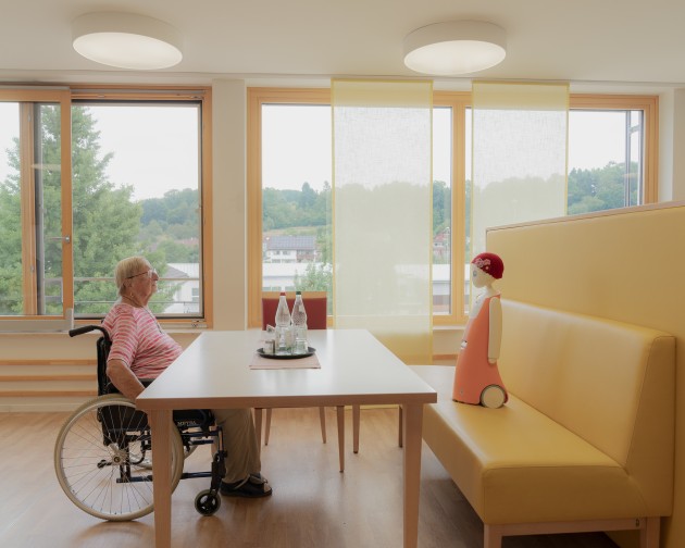 Title: Emma the Social Robot. © Paula Hornickel. 
Waltraud talks with Emma, a social robot that recognizes faces and remembers past conversations. Though skeptical at first, Waltraud says she felt connected to Emma over time. Albershausen, Germany, 3 July 2025.