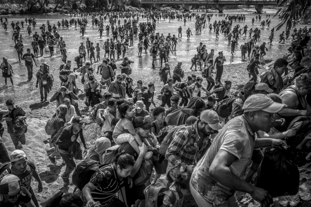 North and Central America, Long-Term Projects, Alejandro Cegarra, The New York Times/Bloomberg. Ever Sosa (center) carries his daughter on his shoulders as they cross the Suchiate River from Guatemala to Mexico, joining a caravan of 3,000 migrants and asylum seekers attempting to get to the United States. In 2019, Mexico granted humanitarian visas for a similar caravan, but by 2020, the policy shifted, calling for the dismantling of any caravan. Thus, thousands were forced to reach Mexico by crossing the Suchiate river rather than using the Dr. Rodolfo Robles International Bridge. Ciudad Hidalgo, Mexico, 20 January 2023