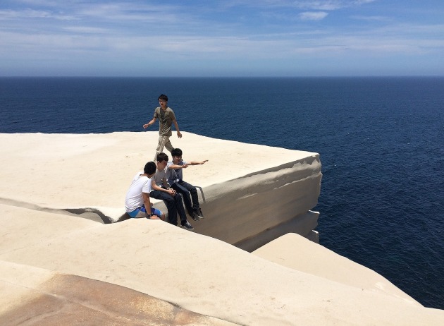 A group of visitors sitting on Wedding Cake Rock, pictured in December 2014, prior to the landmark’s closure to the public.