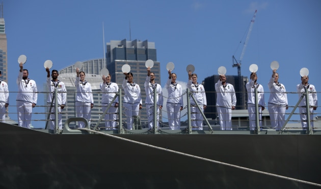 The ship's company of HMAS Brisbane line the upper decks and cheer ship during HMAS Brisbane's commissioning ceremony held at Garden Island. Defence