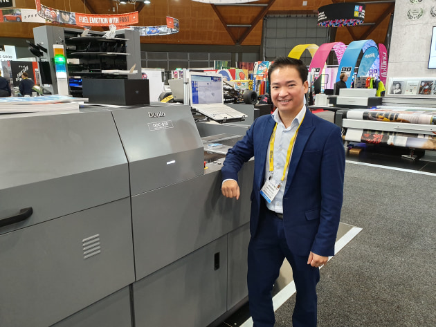 Jimmy Nguyen shows off a Duplo DDC-810 digital spot UV coater on the Neopost stand.